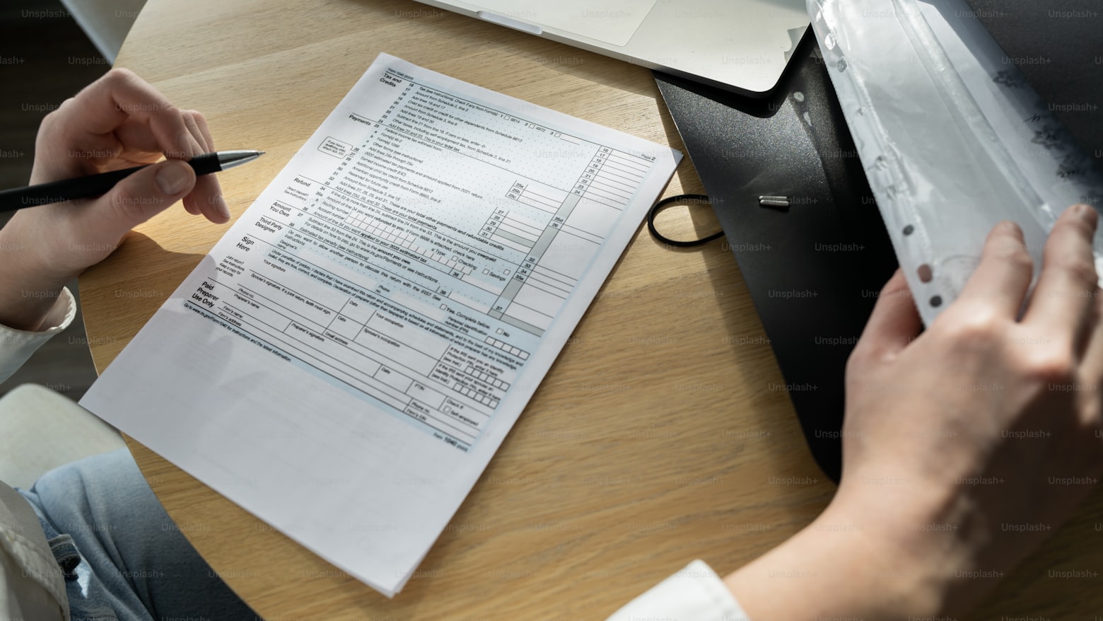 A person checking their credit score on a phone with a credit report on the table
