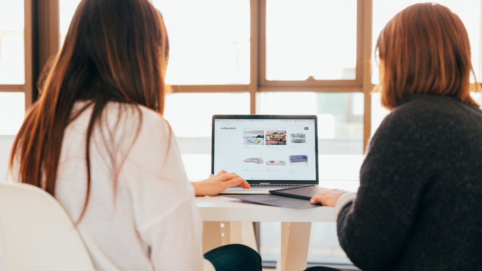 A lender's office with a borrower and cosigner discussing loan options